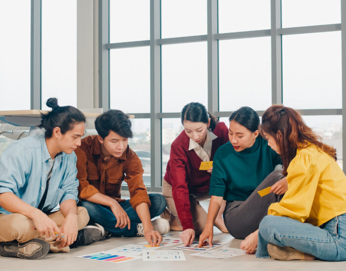 Group of Asia young creative people in casual wear discussing bu