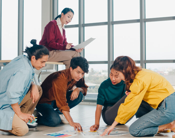 Group of Asia young creative people in casual wear discussing bu