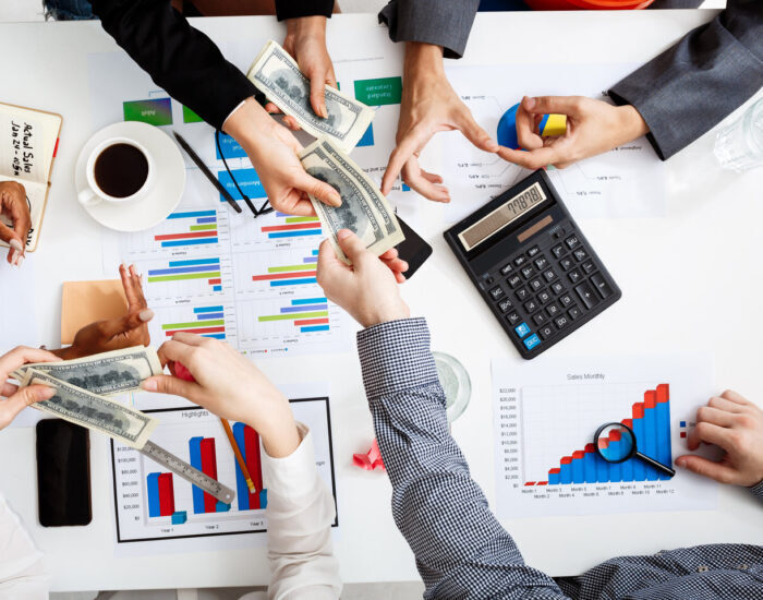 Picture of businessmen's hands on white table with documents and drafts